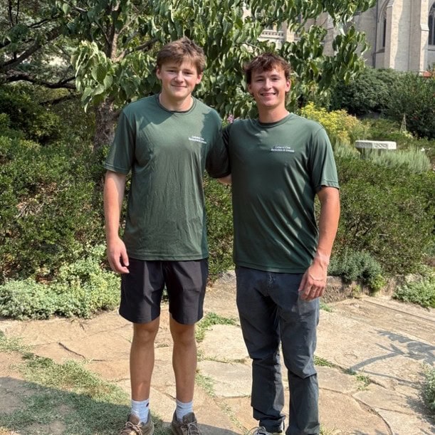 Image of two young men standing in the Bishop's Garden of the National Cathedral.
